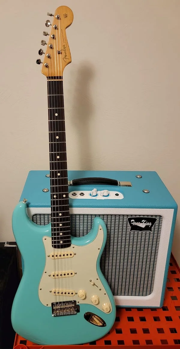 Tone King Gremlin next to a Fender Stratocaster in Miami Blue